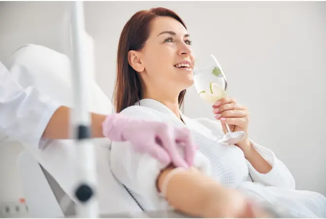 Woman drinking lemon water getting IV Therapy